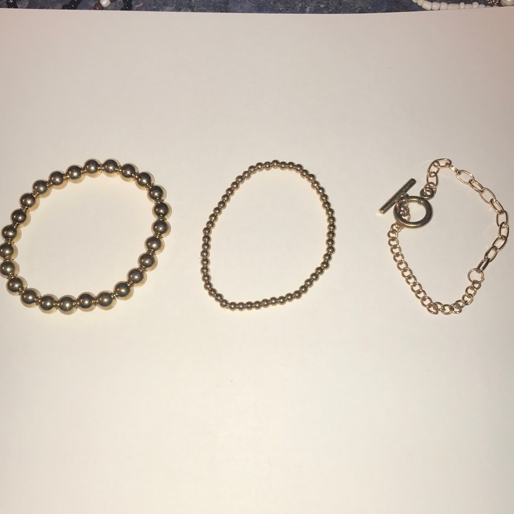 Two gold beaded bracelets and one metal one